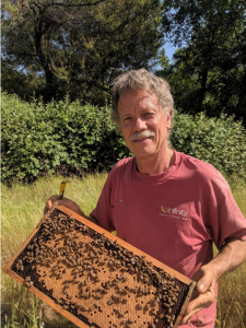 Photo of Randy Oliver holding a frame of bees.